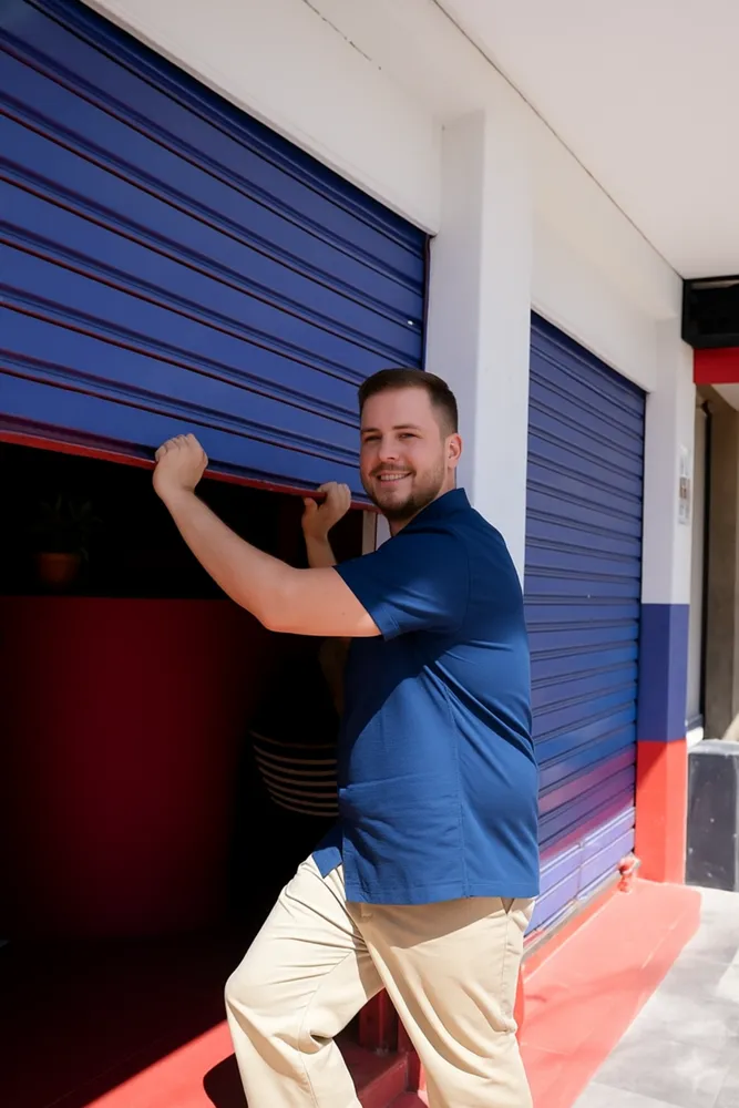 Lojista abrindo a porta da loja pela manhã